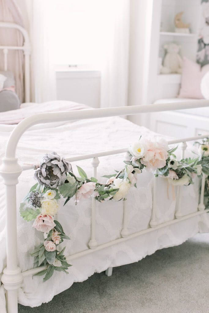 A beautiful garland draped over the foot of a bed.
