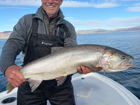 “Proud angler holding a large Pyramid Lake cutthroat trout, a highlight of a guided fly fishing experience.”
