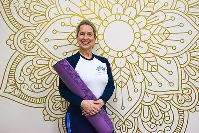 yoga instructor holding a purple mat