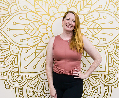 yoga instructor with hand on hip wearing peach top