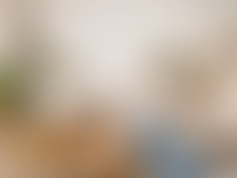 Person relaxing on sofa in cozy living room with plants, calendar marked 2026, cleaning supplies, and folded towels. Peaceful ambiance.