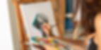 Artist painting a colorful portrait on canvas, holding a palette and brush. Earthy studio setting with focus on creative process.