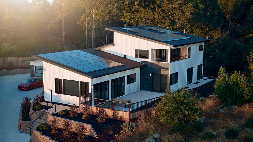 Single-story suburban house with solar panels, palm trees, and a garage under a bright blue sky with clouds.