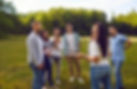 Group of happy friends or corporate coworkers standing on grass in summer park on weekend
