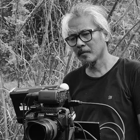 Le réalisateur Lav Diaz qui regarde le retour d'une caméra. L'image est en noir et blanc