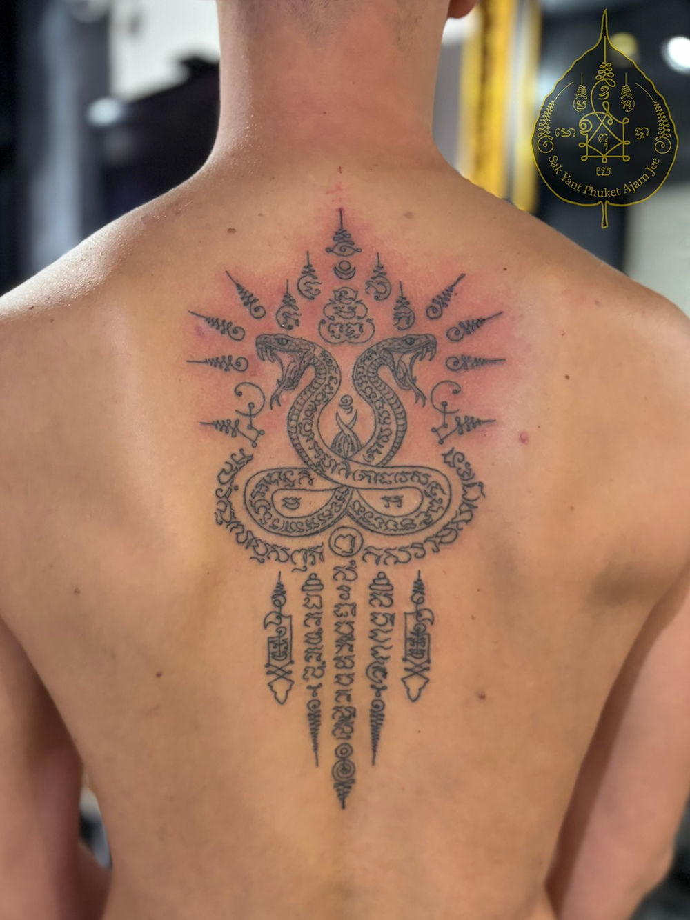 Best Sak Yant Tattoo Patong Phuket with twin cobras traditional Thai back tattoo