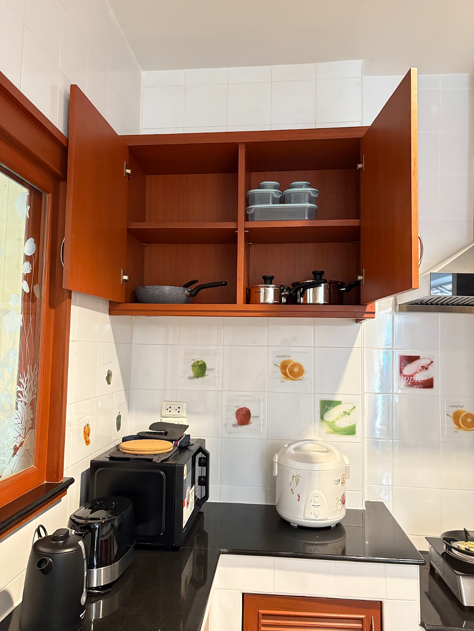 Fully equipped kitchen with a refrigerator and complete cooking essentials.