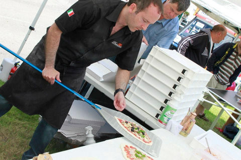 Pizza being placed on a metal pizza peel