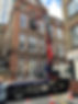 Lorry lifting a heavy load into a second floor window