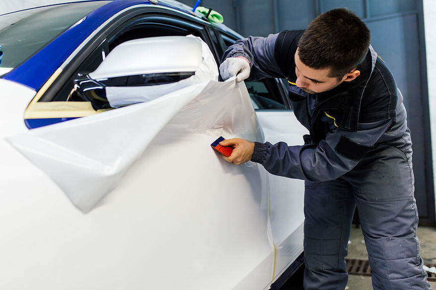 Man applying vehicle wrap to car