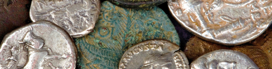 Diverse oude munten met gezichten, dierenfiguren, zilver en geoxideerd brons.