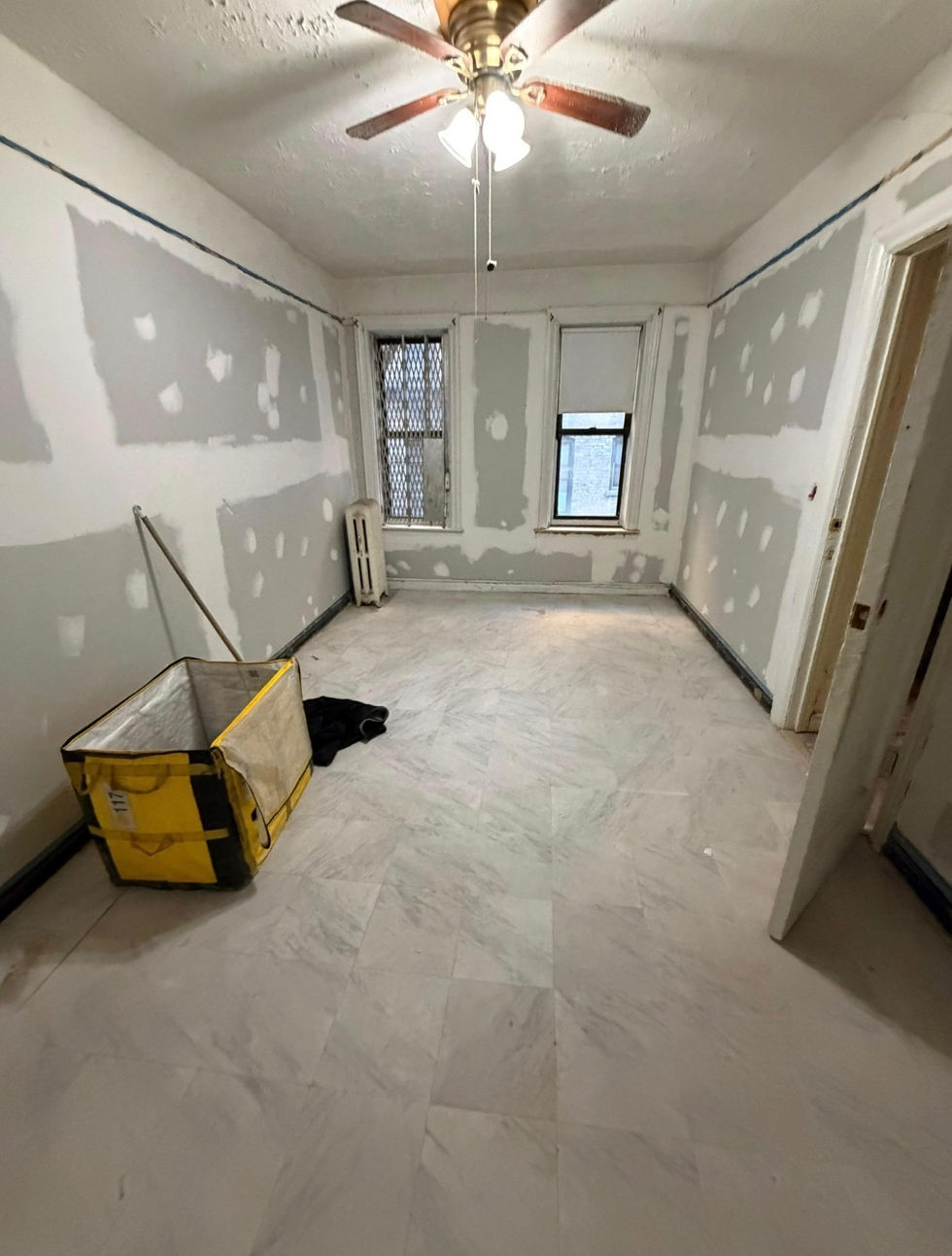 Light-colored tile flooring in a Kingsbridge, Bronx room during renovation.
