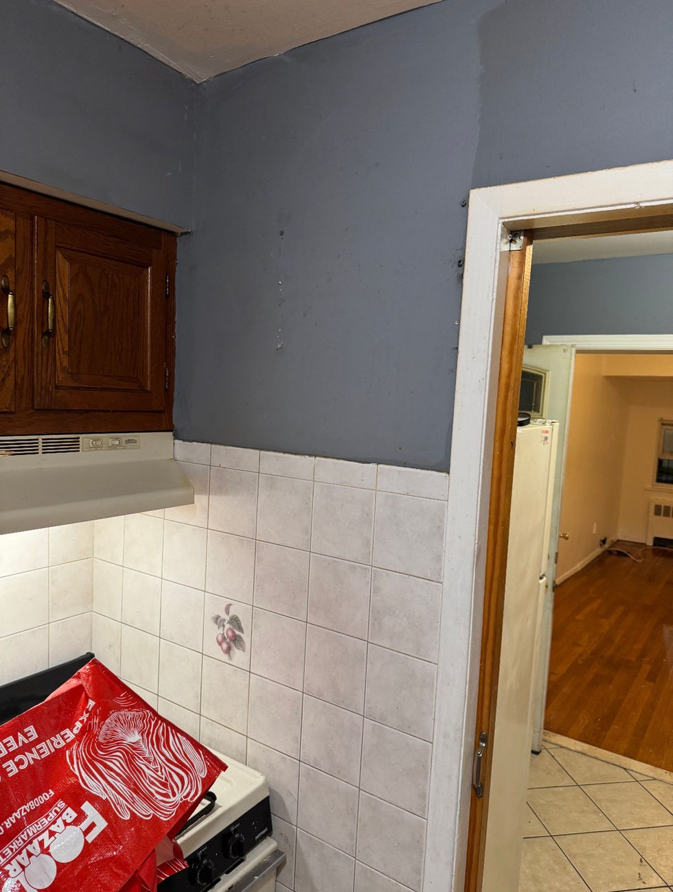 Blue kitchen wall above white tile backsplash beside a doorway