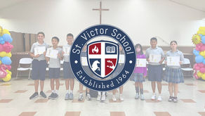 Students recognized for exemplifying St. Victor School's Student Learning Expectations stand with their certificates during the trimester awards ceremony. The awards honor students who demonstrate the qualities of Child of Faith, Lifelong Learner, and Caring & Responsible Citizen.