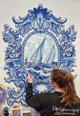 Artist painting a blue and white sailboat mural