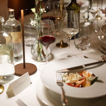 Elegant dinner table setting: wine, salad, flowers