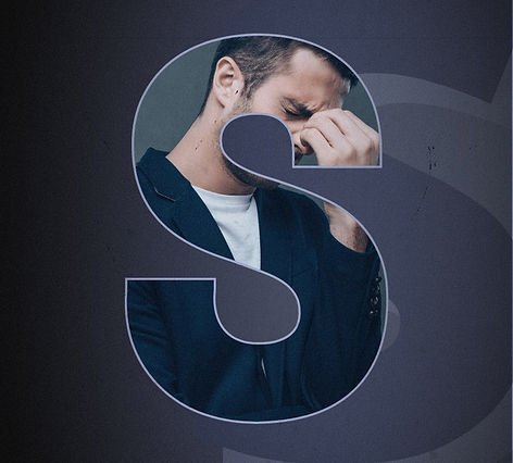 Man, head bent over, eyes tightly closed and touching the bridge of his nose due to the stress he is under