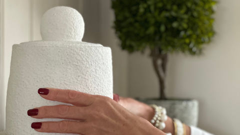 Home decor and accessories for beautiful interiors. White Jar being placed on shelf in living room.