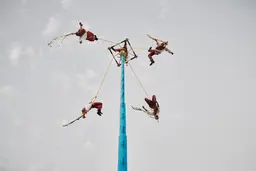 Dynamic shot of "Voladores" dancers mid-air during their descent in Playa del Carmen, Mexico. Personal project by lifestyle photographer Celso Marrero.
