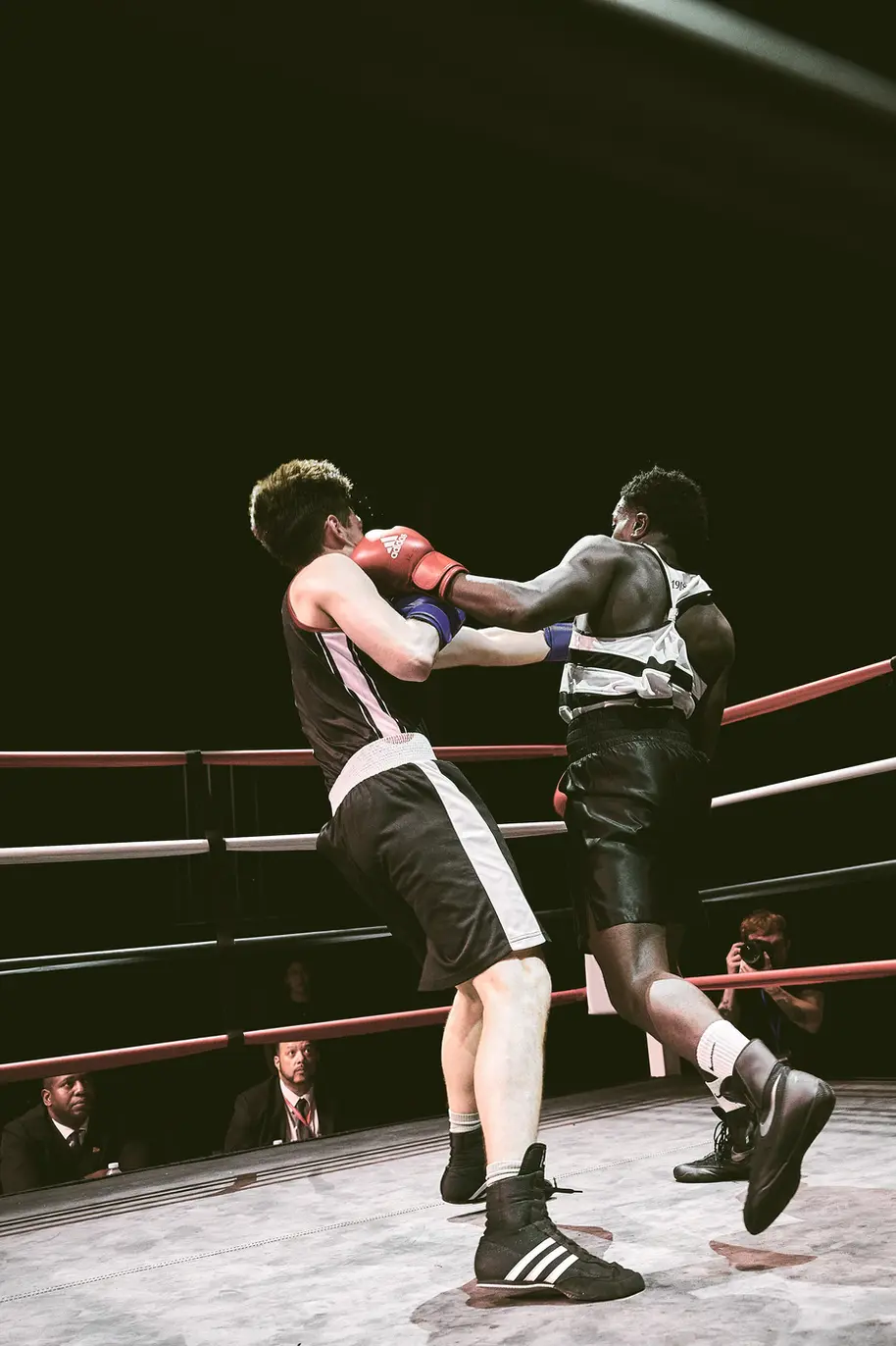 Sports and lifestyle photography by Celso Marrero capturing an intense boxing match, showcasing dynamic action and dramatic lighting.