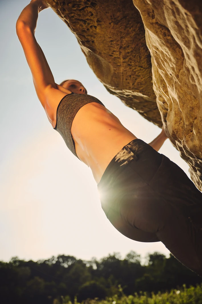 Female rock climber scaling a rock face, displaying focus and determination. Photographed by sports photographer in London Celso Marrero.