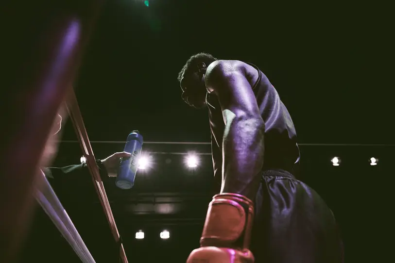 Sports and lifestyle photography by Celso Marrero, capturing an intense moment in boxing, with dramatic lighting and focus on the athlete's determination.