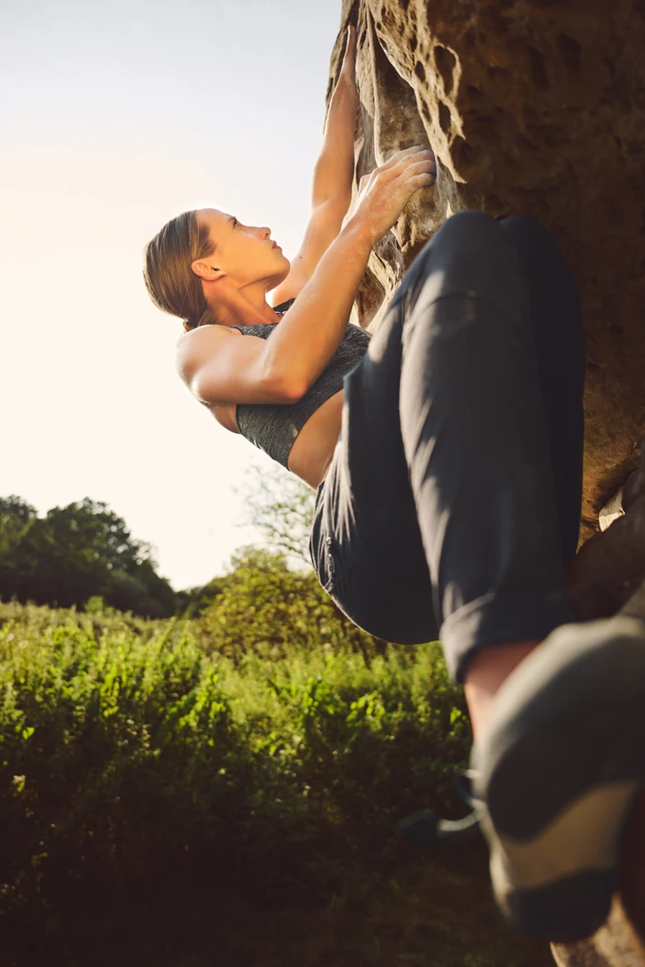 Female rock climber scaling a rock face, displaying focus and determination. Photographed by sports photographer in London Celso Marrero.