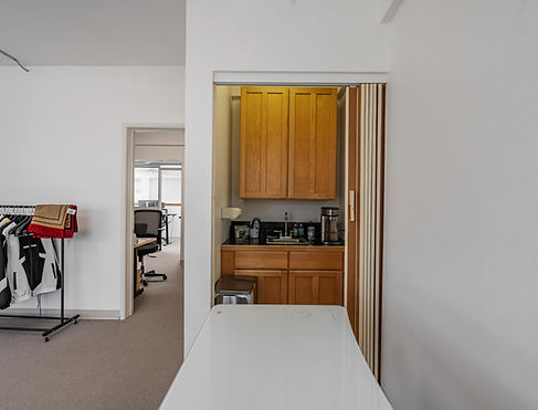Small kitchen area with cabinets and appliances, visible from doorway.