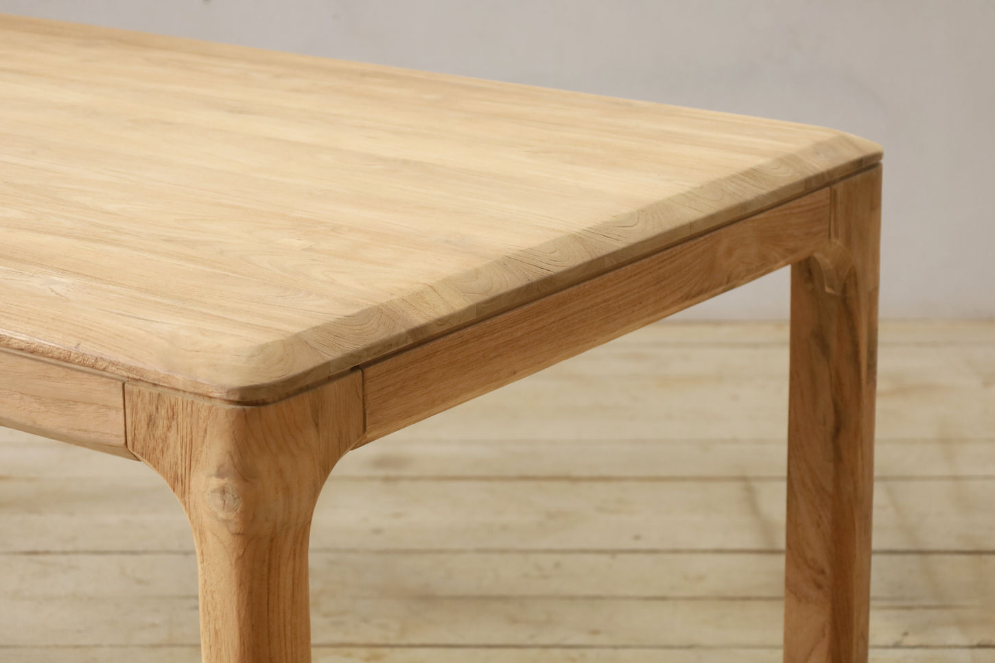 Toraja dining table in reclaimed teakwood, featuring a modern design with soft curvy edges.