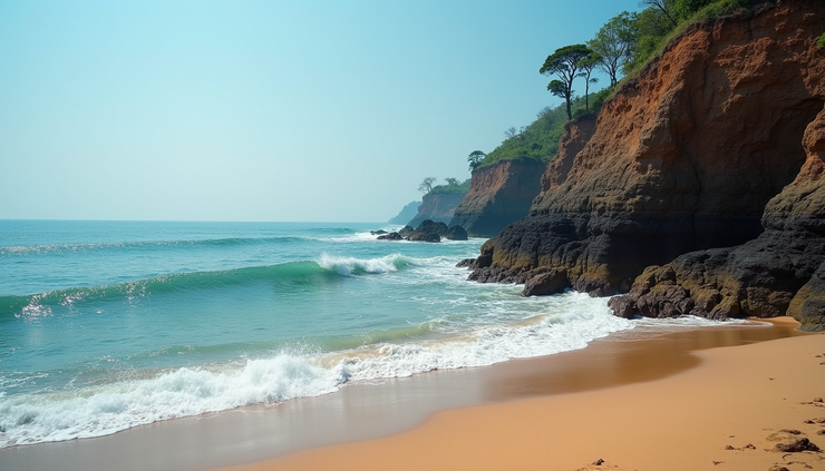High angle view of rocky cliffs overlooking a sandy beach with blue sea waves