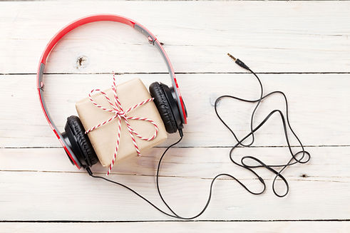 Gift box with headphones on wooden table. Top viw.jpg