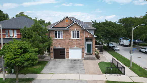 Drone photo of a detached brick home and driveway in Burlington, Ontario