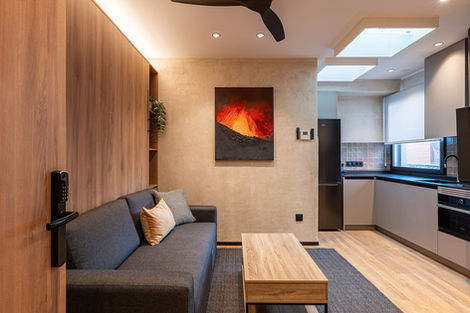 salon con mesa de centro, sofá y cuadro rojo y tierra