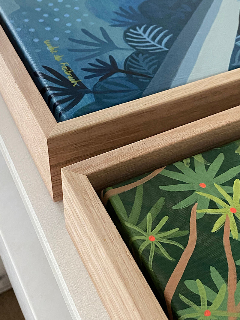 a close up of two paintings framed in wood