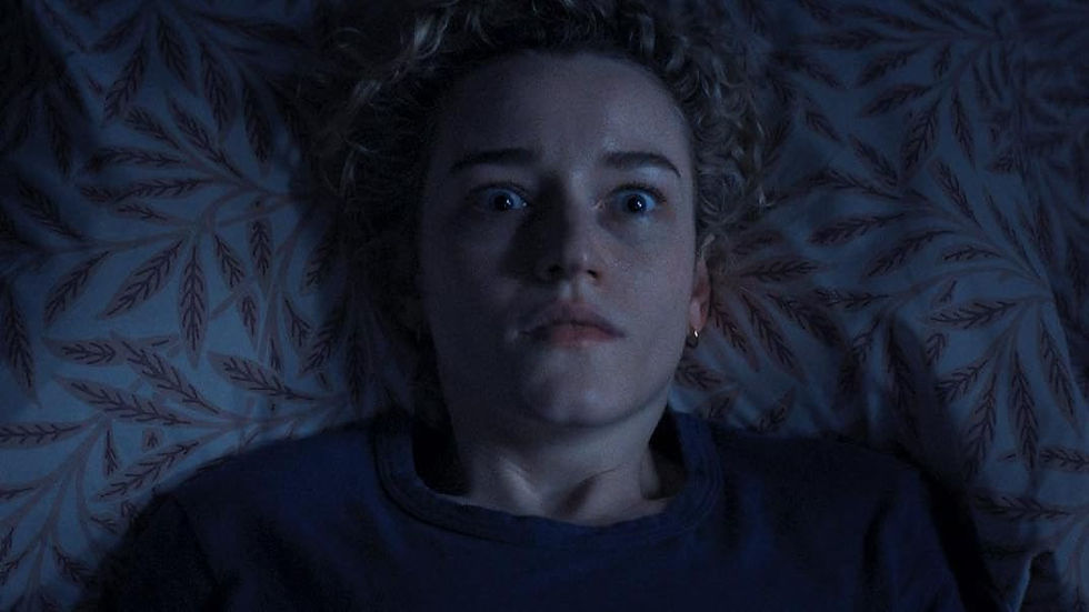 Justine Gandy (Julia Garner) in her bed staring at the ceiling while petrified.