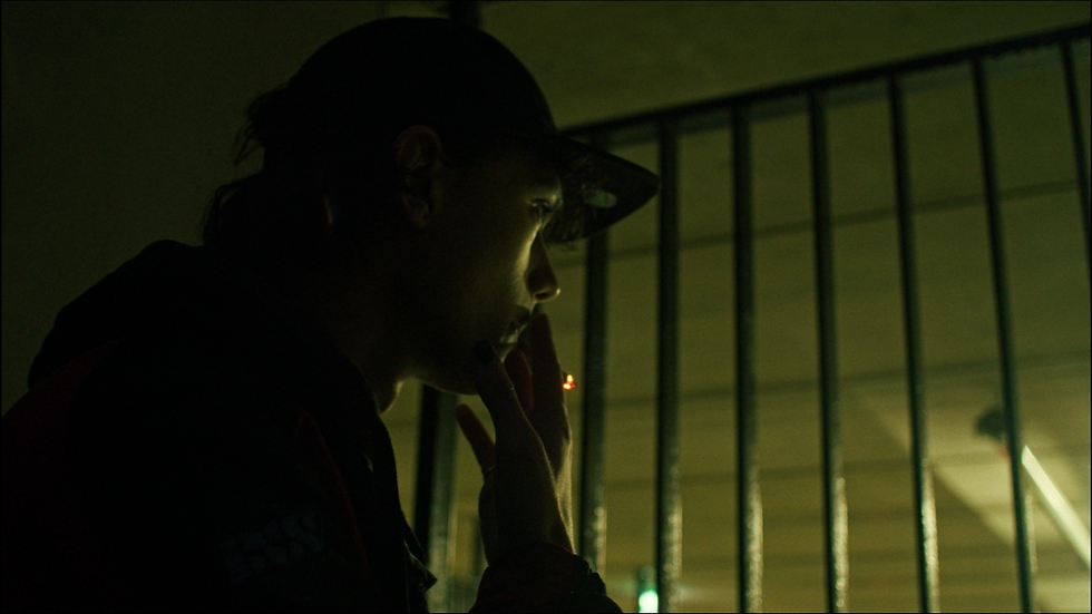 Smoking guy at a fence during the night