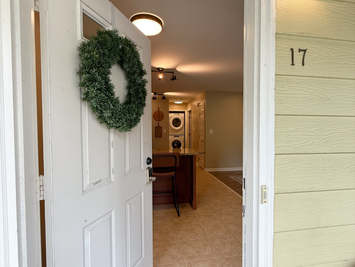 Open front door at unit 17 showing the tile entry and kitchen, self check in at The Brownsboro, Louisville KY