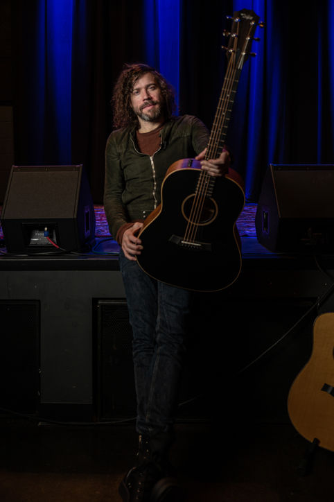 Music artist Josh Krajcik holding black Taylor Guitar