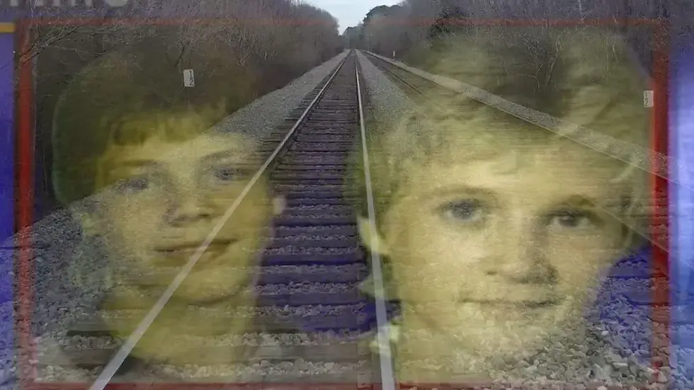 Eye-level view of a quiet train track surrounded by trees