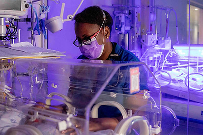 South African neonatologist treating a newborn in an incubator