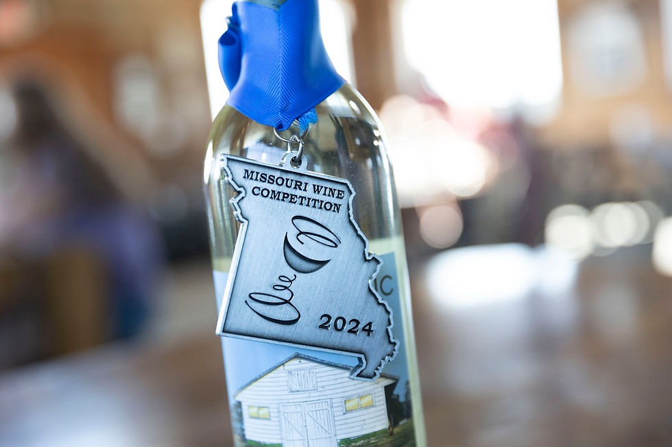 Edg Clif award winning Wine bottle with a silver medal labeled "Missouri Wine Competition 2024," blue ribbon, on wooden table, blurred rustic background.