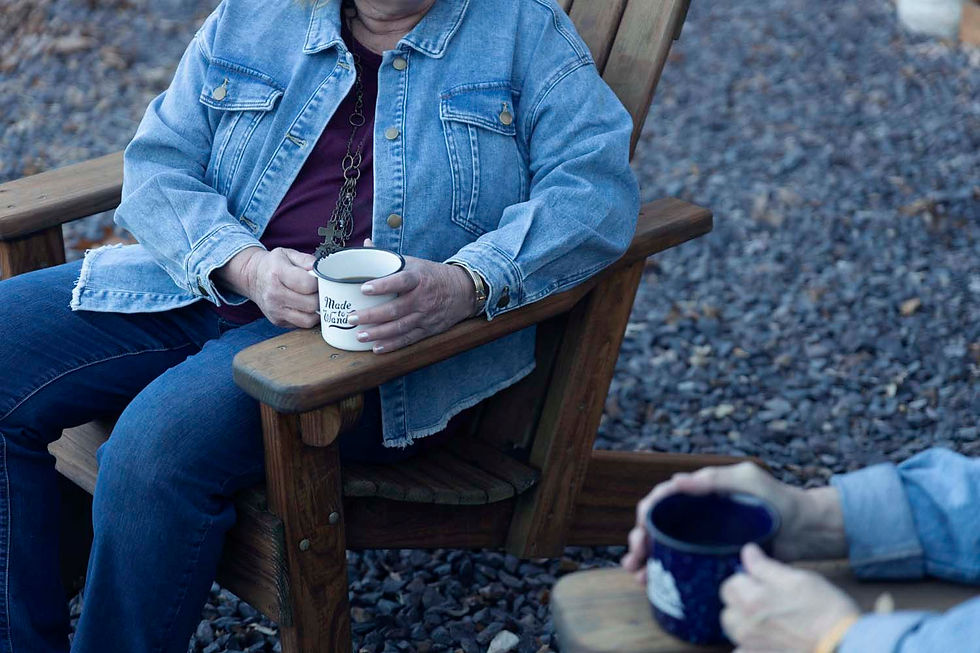 The two women sitting in chairs with coffee mugs in hand