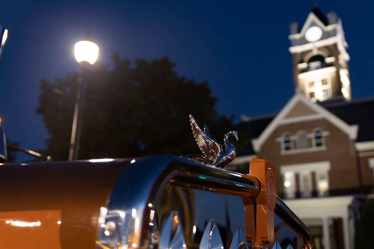 Picture of the frontside of a truck with a building in the background