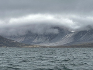 grey, puffy clouds over blue ocean