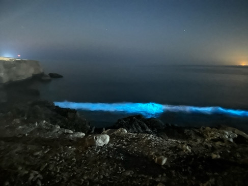 blue light waves crashing on the beach