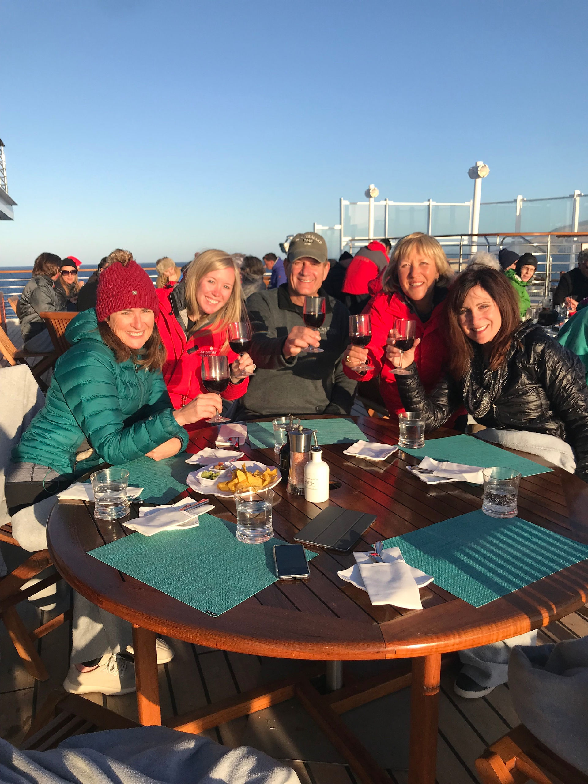 people sitting around a table with wine