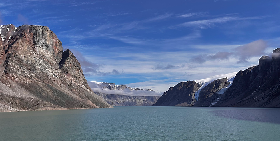 blue ocean water with grey and black cliffs on either side