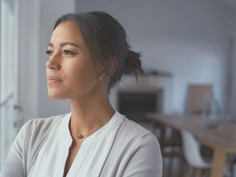 woman in white shirt looking out window