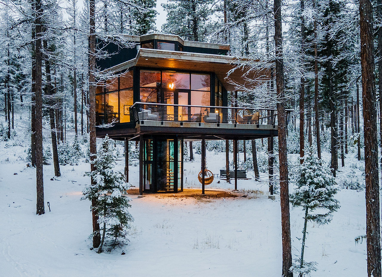 elevated modern house in a snow covered forest