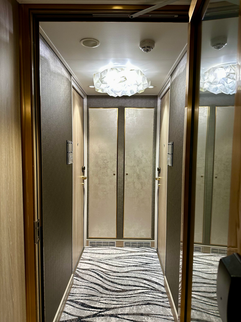 hallway with door and chandelier